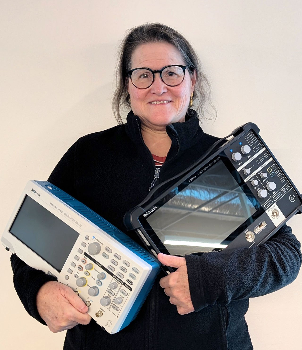 Tektronix Entry Oscilloscopes product manager, Cyrilla Menon, holding the 2 Series MSO EDU and TBS1052C-EDU