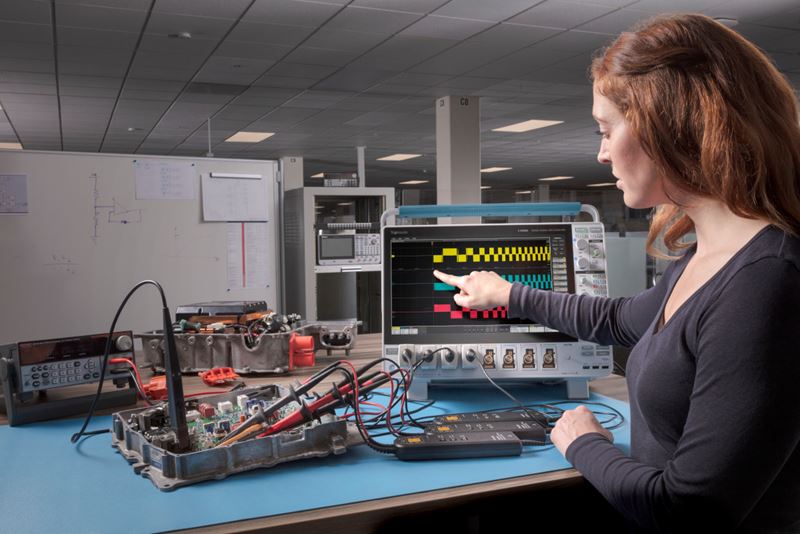 Engineer using the Tektronix 5 Series B Mixed Signal Oscilloscope to performing electric vehicle power train testing.