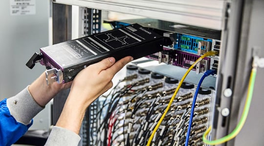 MP5000 racked in a system engineer inserts PSU in the rear