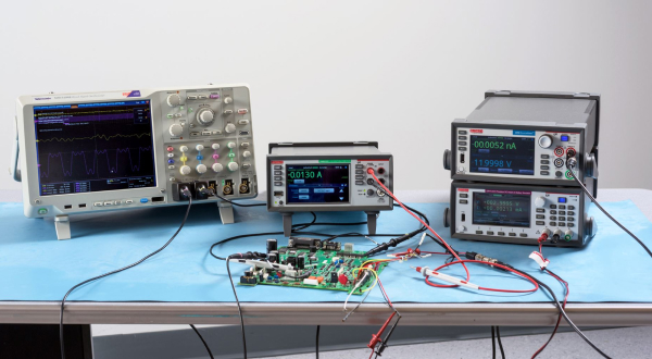 An electronics workbench setup with three Keithley digital multimeters testing a breadboard with electronic components