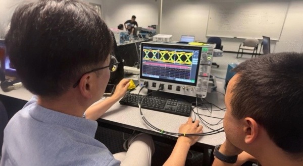 Engineers using Tektronix oscilloscope and DJA software for jitter analysis